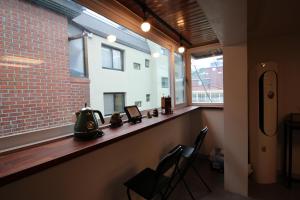 a room with a counter with two chairs and a window at Bunk Backpackers Guesthouse in Seoul