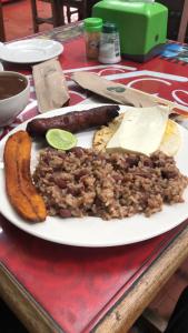 a plate of food with sausage and beans and cheese at Hotel cambulos in Manizales