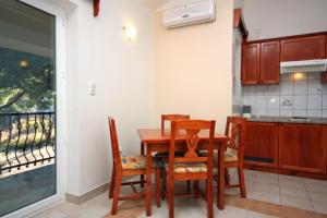 a dining room with a table and chairs and a kitchen at Apartments by the sea Rogoznica - 3094 in Rogoznica