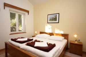 a bedroom with a bed with two robes on it at Apartments by the sea Rogoznica - 3094 in Rogoznica