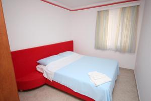 a bedroom with a red bed and a red chair at Apartments with a parking space Slano, Dubrovnik - 3184 in Slano