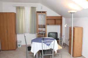 a dining room with a table and chairs and a tv at Apartments with a parking space Slano, Dubrovnik - 3184 in Slano