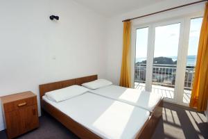 a bedroom with a bed and a large window at Apartments with a parking space Duce, Omis - 3190 in Duće