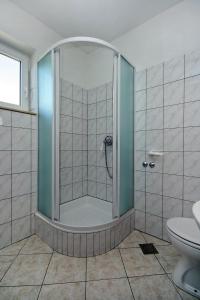 y baño con ducha y puerta de cristal. en Apartments with a parking space Duce, Omis - 3190, en Duće