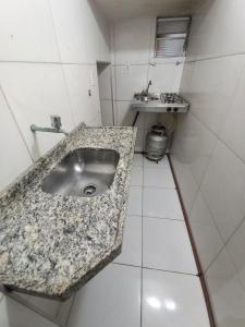 uma casa de banho com um lavatório em granito no chão em Iracema Praia Flats em Fortaleza