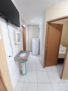 uma pequena casa de banho com um lavatório e um frigorífico em Iracema Praia Flats em Fortaleza