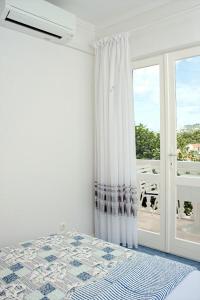 a bedroom with a bed and a large window at Double Room Zivogosce - Porat 2733a in Živogošće