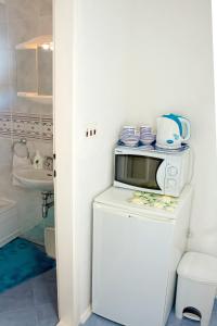 a kitchen with a microwave on top of a refrigerator at Double Room Zivogosce - Porat 2733a in Živogošće