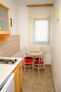 a kitchen with a table and chairs and a table at Apartments and rooms with parking space Krk - 3231 in Vrh