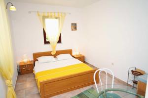 a bedroom with a bed with yellow sheets and a window at Studio Krk 3231a in Vrh