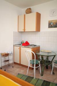 a kitchen with a table and a table and a table and chairs at Studio Krk 3231a in Vrh