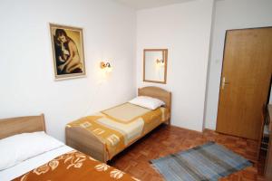 a small room with two beds and a door at Triple Room Krk 3231a in Vrh