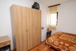 a bedroom with a large wooden cabinet with a bed at Triple Room Krk 3231a in Vrh