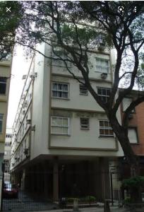 a white building with a tree in front of it at prudente 304 in Rio de Janeiro