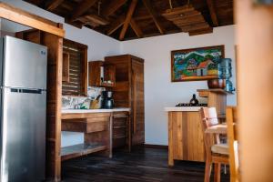 una cocina con nevera de acero inoxidable y armarios de madera en Selá Nicaragua, en El Gigante