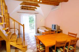 a living room with a dining room table and a television at Apartments with swimming pool Jadranovo, Crikvenica - 3238 in Jadranovo