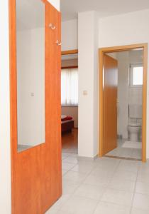 La salle de bains est pourvue de toilettes et d'une porte en bois. dans l'établissement Apartment Vinjerac 3248c, à Vinjerac