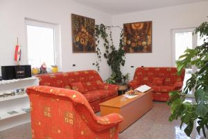 een woonkamer met twee rode banken en een tafel bij Studio Vinjerac 3248f in Vinjerac
