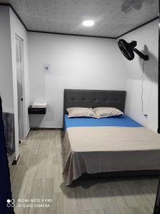 ein Schlafzimmer mit einem großen Bett mit einer blauen Decke in der Unterkunft Cabañas Mirador La Roca in Melgar