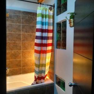cortina de ducha de arco iris en el baño con bañera en Apartamento la 15 en Pereira