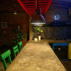 a kitchen with a long counter with green chairs at Apartamento la 15 in Pereira
