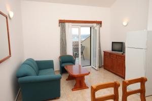 a living room with two chairs a table and a refrigerator at Apartments by the sea Rogoznica - 3262 in Rogoznica