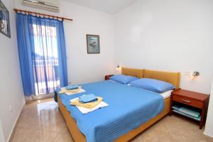 a bedroom with a bed with blue sheets and a window at Apartments with a parking space Hvar - 3229 in Hvar