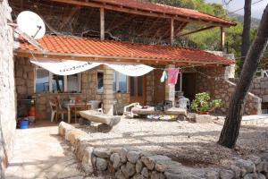 a stone house with an umbrella in front of it at Family friendly seaside apartments Jagodna, Hvar - 3250 in Jelsa