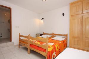 a bedroom with a bed with an orange blanket at Family friendly seaside apartments Jagodna, Hvar - 3250 in Jelsa