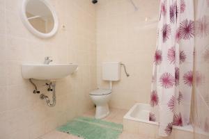 a bathroom with a toilet and a sink and a shower curtain at Family friendly seaside apartments Jagodna, Hvar - 3250 in Jelsa