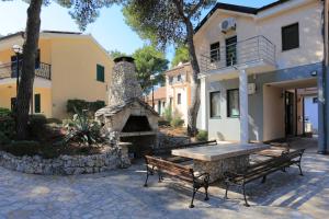 a picnic table and benches in front of a house at Double Room Rogoznica 3266a in Rogoznica +8 photos