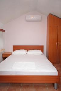Schlafzimmer mit einem großen Bett mit einem Kopfteil aus Holz in der Unterkunft Double Room Rogoznica 3266a in Rogoznica