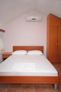 a bedroom with a large bed with a wooden headboard at Double Room Rogoznica 3266a in Rogoznica
