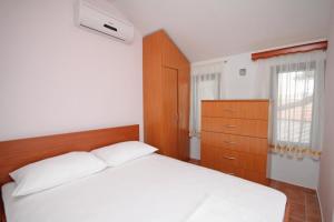 a bedroom with a white bed and a dresser at Double Room Rogoznica 3266a in Rogoznica