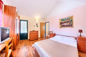 um quarto com uma cama e uma televisão de ecrã plano em Apartments and rooms by the sea Rogoznica - 3266 em Rogoznica