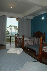 a bedroom with three beds and a large window at Espaço Indio Tupi in Trindade