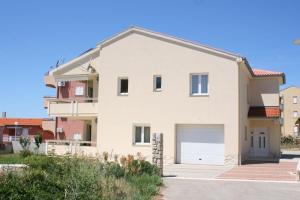 a white house with a garage at Apartments with parking space Novalja, Pag - 3294 in Novalja