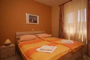 a bedroom with a bed with towels on it at Apartments with parking space Novalja, Pag - 3294 in Novalja