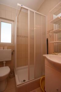 a bathroom with a shower and a toilet and a sink at Apartments with parking space Novalja, Pag - 3294 in Novalja +40 photos