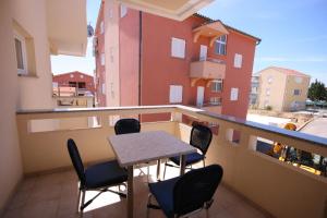 a balcony with a table and chairs on a balcony at Apartments with parking space Novalja, Pag - 3294 in Novalja