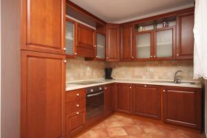 a kitchen with wooden cabinets and a sink at Apartments with a parking space Novalja, Pag - 3299 in Novalja