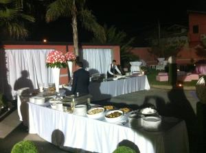 two people standing at a buffet table with food at Hotel Hermitage in Qualiano