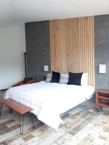 a bedroom with a large white bed and a table at Casa Nicolás in Valle de Bravo