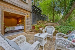 un patio con sillas de mimbre, una mesa y una cama en Log-Cabin Home Retreat - Walk to Restaurants Trails Hiking & Biking en Palo Alto
