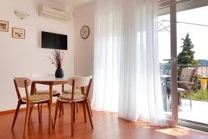 ein Esszimmer mit einem Tisch, Stühlen und einem Fenster in der Unterkunft Apartments by the sea Rovinj - 3373 in Rovinj