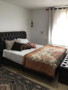 Schlafzimmer mit einem Bett und einem Fenster in der Unterkunft Espaço Jardim Curitiba in Curitiba