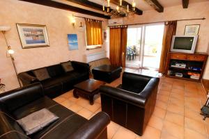 a living room with leather furniture and a television at Family friendly house with a swimming pool Visnjan - Strpacici, Central Istria - Sredisnja Istra - 3351 in Višnjan