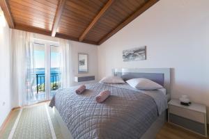 1 dormitorio con 1 cama con 2 almohadas en Apartments and rooms with parking space Brela, Makarska - 2717 en Brela