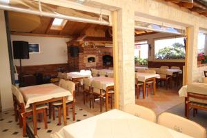 a restaurant with tables and chairs and a fireplace at Apartments by the sea Povljana, Pag - 3316 in Povljana