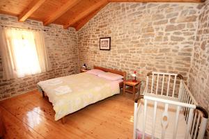 una camera da letto con un letto e un muro di mattoni di Family friendly house with a swimming pool Orihi, Central Istria - Sredisnja Istra - 3334 a Barban Altre 33 foto